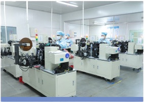 Row of automated winding and cell assembly machines with operators